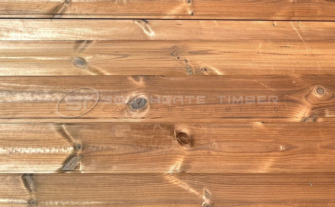 Thermowood Pine 20 x 140mm TGV ST1.TW cladding boards with a rich brown tone, smooth surface, and natural knots, durable exterior timber cladding from Southgate Timber.